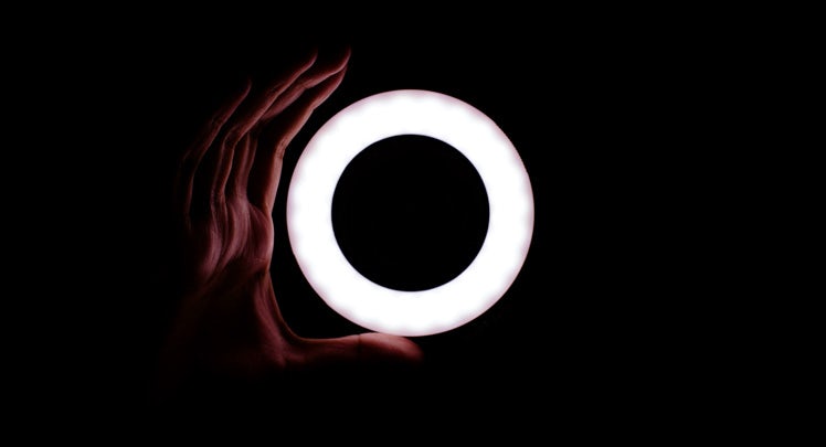A person's hand is holding a light up ring.