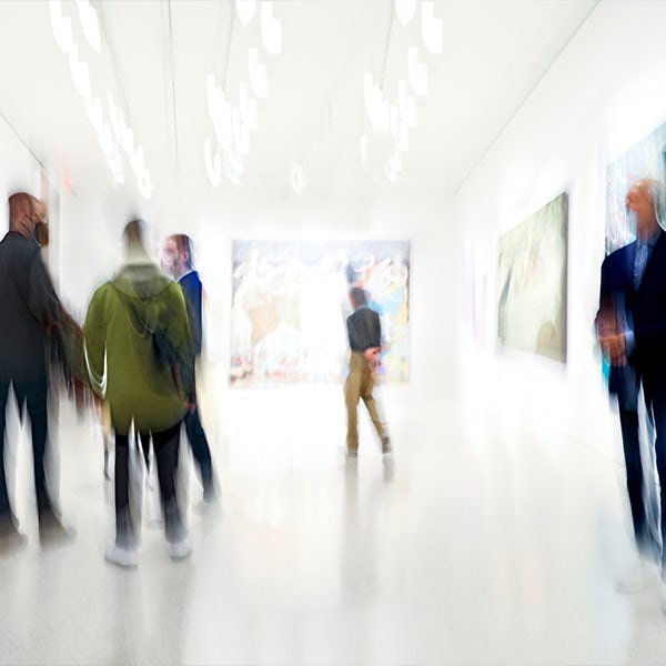 A group of people walking through an art gallery.