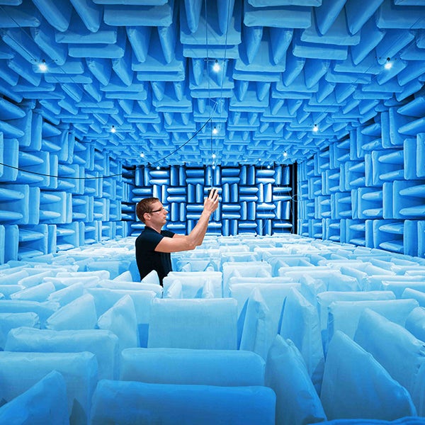 A man is taking a picture in a blue room.