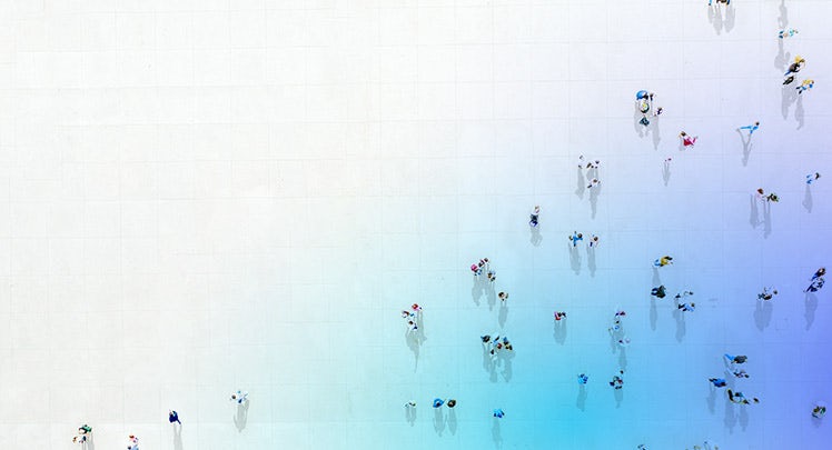 A group of people walking on a blue and white wall.