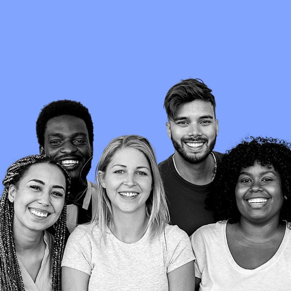 A group of people smiling in front of a blue background.