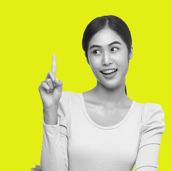 Asian woman pointing finger over yellow background.