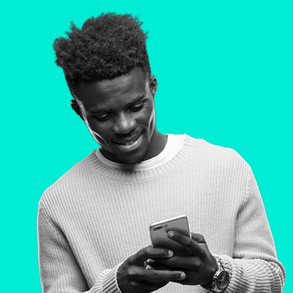 A man is smiling while using a cell phone.