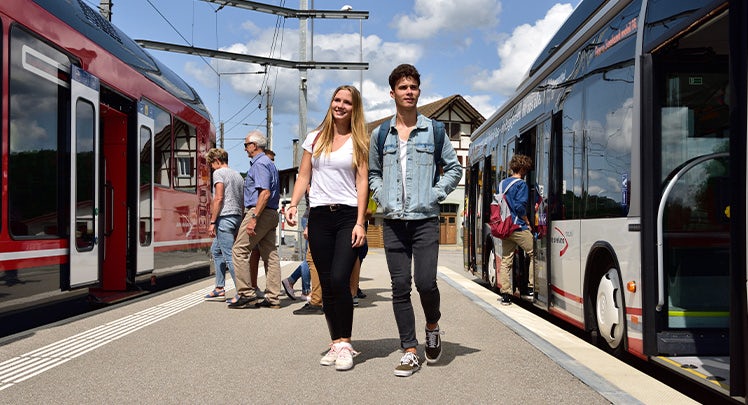 Two people standing on a platform next to a train.
