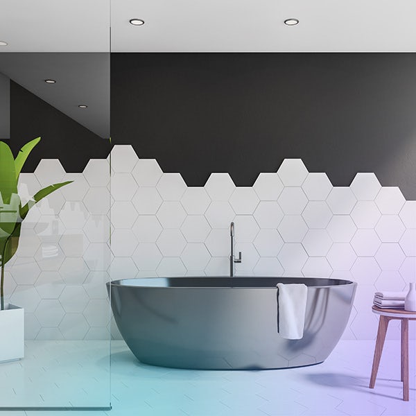 A bathroom with black and white tiles and a tub.