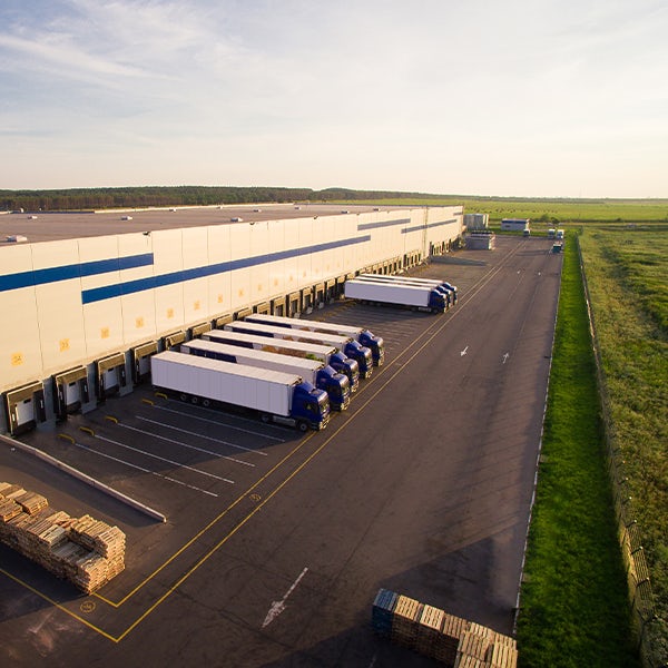 An aerial view of a warehouse with trucks parked in front of it.