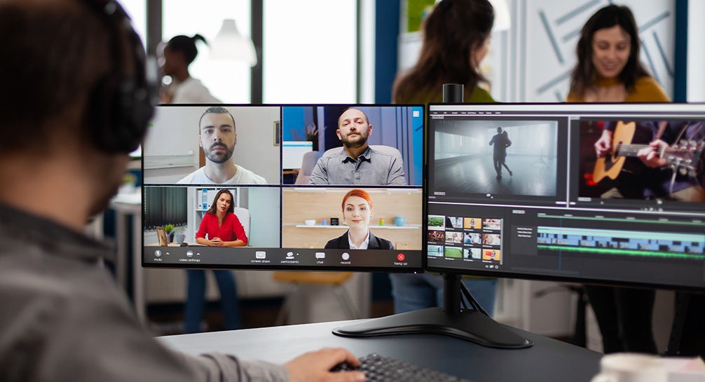 A group of people in a conference room using video conferencing.