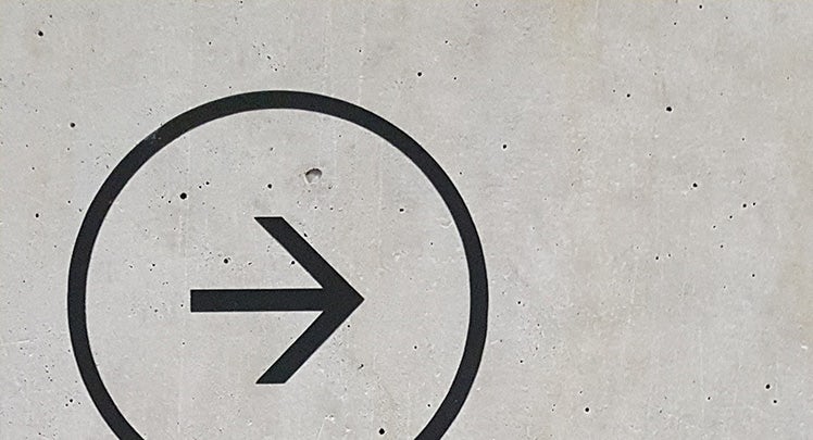 A black arrow on a concrete wall.