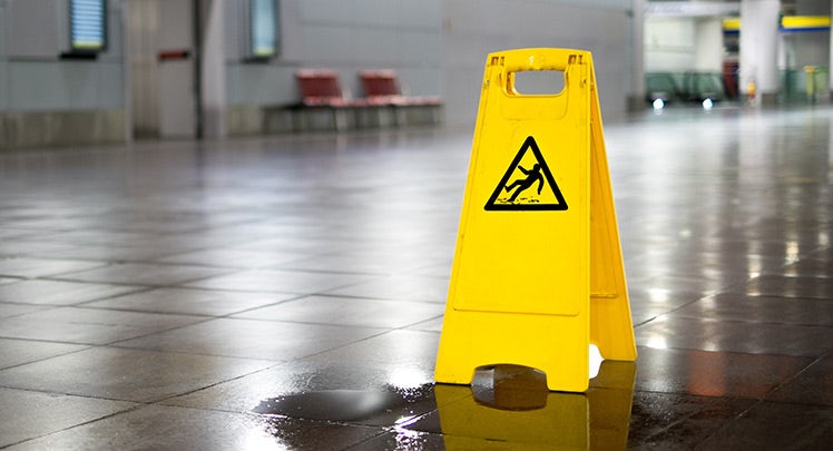 A yellow caution sign in the middle of a puddle.