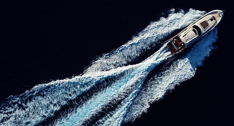 An aerial view of a boat speeding through the water.