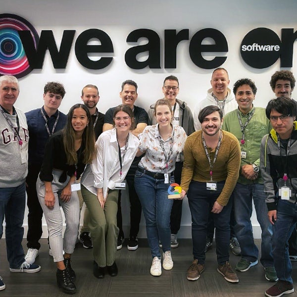 A group of people posing in front of a we are one sign.