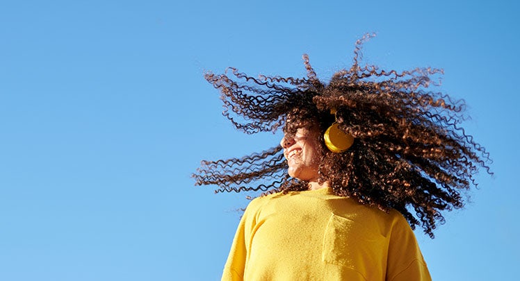 A young girl with a big afro blowing in the wind.