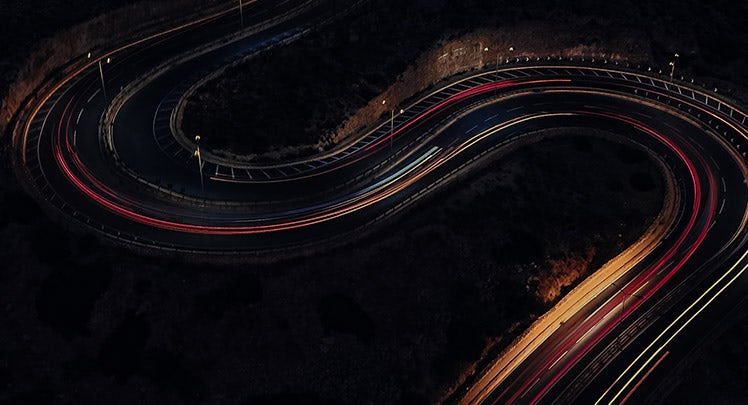 An aerial view of a winding road at night.