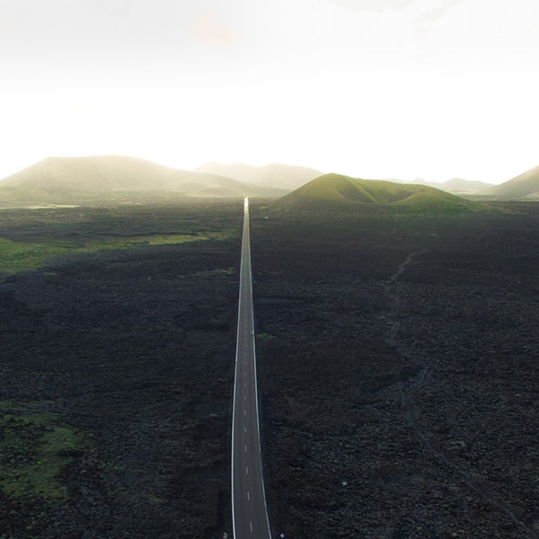 An aerial view of a road in the middle of a lava field.