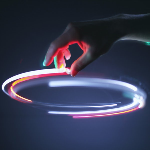 A person is holding a glowing hula hoop.