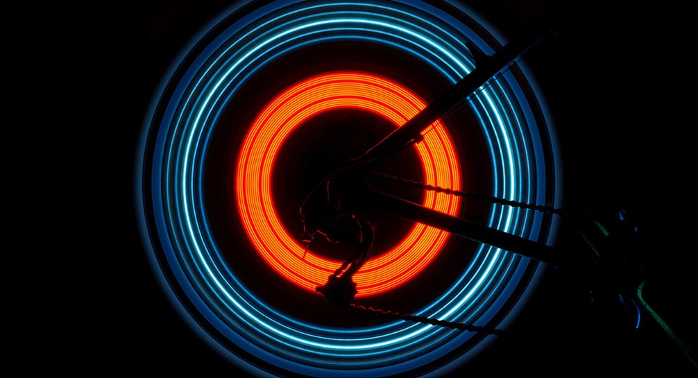 A bicycle wheel with neon lights on it.