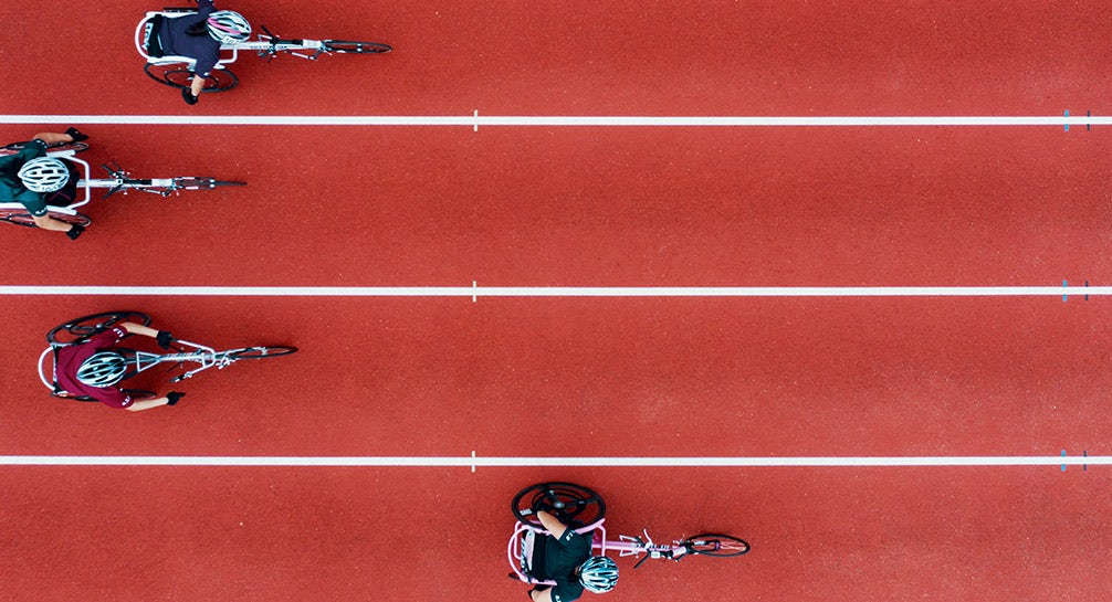 A group of people riding bikes on a track.