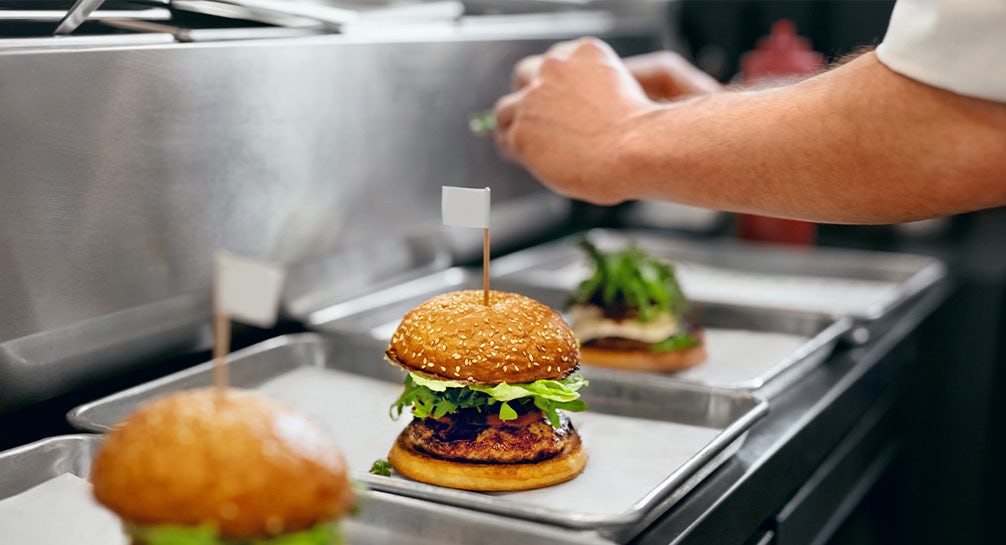 A person preparing a burger