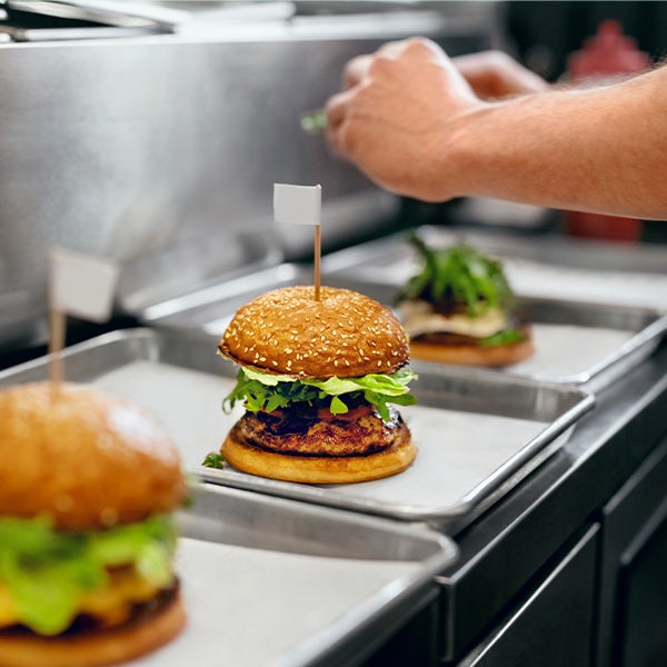 A person preparing a burger