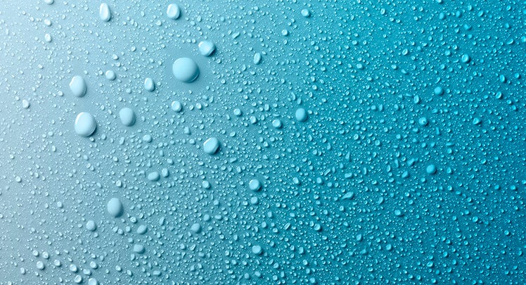 A close up of water droplets on a blue background.