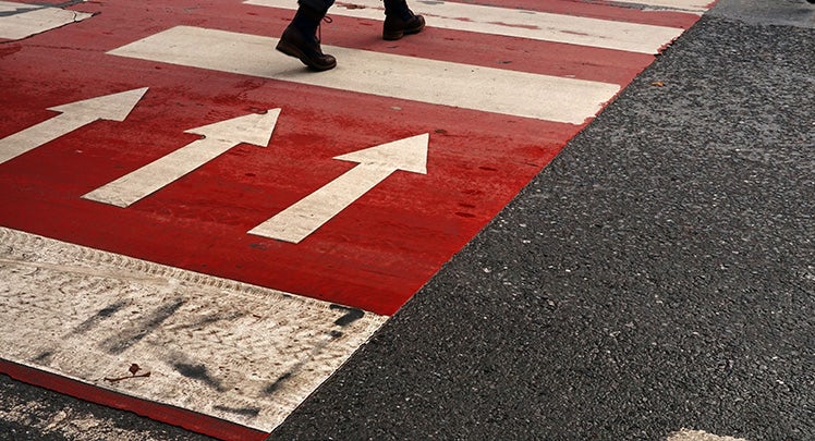 A red and white crosswalk with arrows on it.