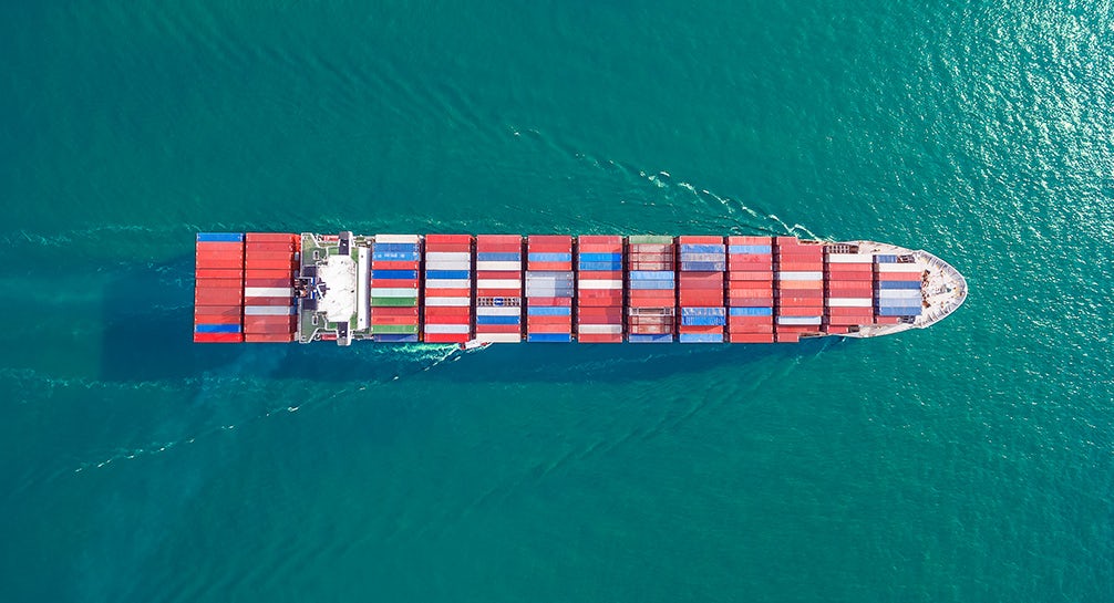 An aerial view of a container ship in the ocean.