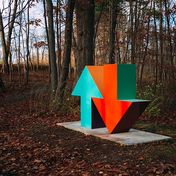 Sculpture in the forest with a green arrow pointing upwards and a red arrow pointing downwards