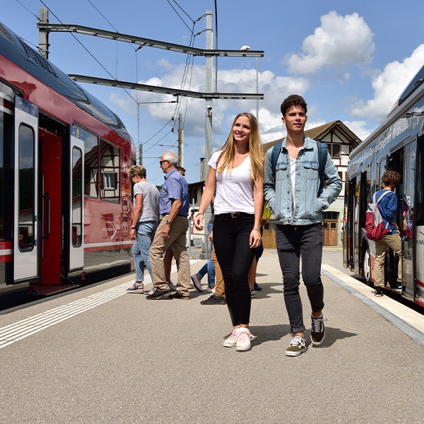 Two people standing next to a train.