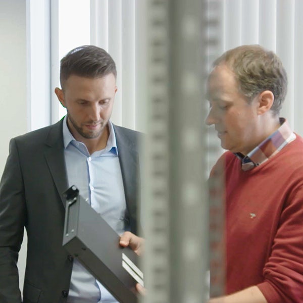 Two men looking at a folder in an office.