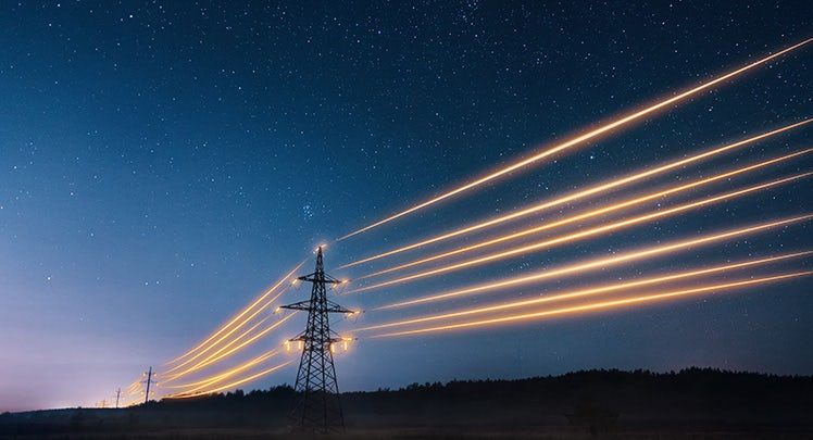 High voltage lines at night with a starry sky.