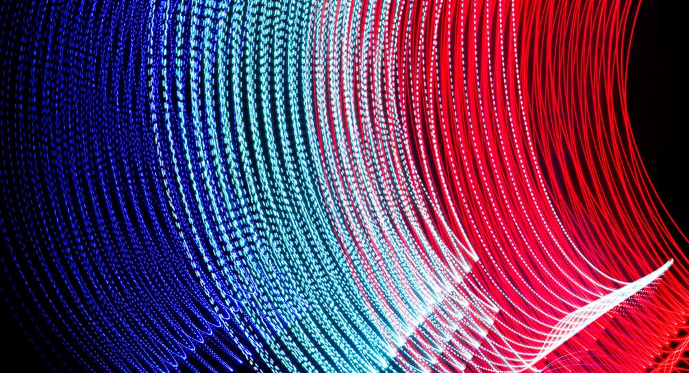 A red, blue, and white light wave on a black background.