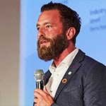 A man with a beard speaking into a microphone.