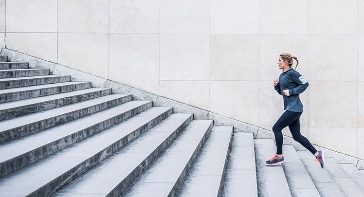 A woman jogging down a set of stairs.