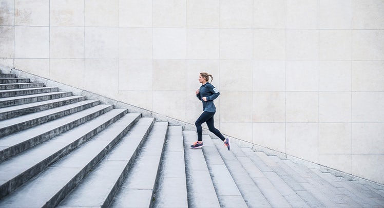 A woman jogging down a set of stairs.